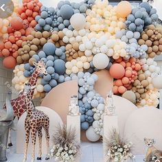 an animal themed birthday party with balloons and giraffes on the side wall