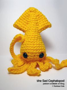 a crocheted yellow octopus with black eyes