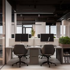 an office cubicle with two desks and three monitors