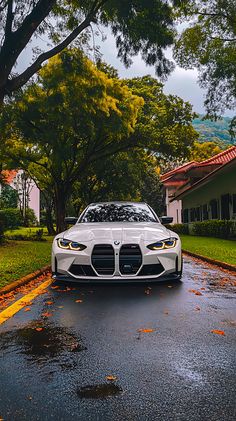 a white sports car is parked on the side of the road in front of some houses