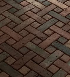 a dog laying on the ground next to a brick walkway