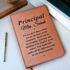 a brown book sitting on top of a desk next to a pen