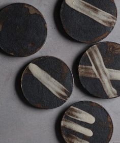 four black and white plates with forks on them sitting next to each other in front of a gray background