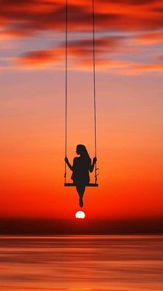 a person swinging on a swing at sunset