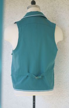 A bit of the 1950s or early 1960s in a rockabilly vest. We love to make custom pieces. And this piece was made especially for a client with custom pipings on the collar and body, flap pockets, a back yoke, and an amazing sea green 100% wool tricotene for an authentic retro look. We love to make custom pieces. And classic Western wear looks are always fun for us. So if you play in an classic country band----keep our card in your back pocket. ------------------------------------------------------- Western Vest Pattern, Fitted Vintage Denim Vest With Snap Buttons, Vintage Denim Vest With Button Closure, Vintage Button-up Denim Vest, Vintage Button-up Cotton Denim Vest, Country Bands, Sea Green, Retro Look, Flap Pocket