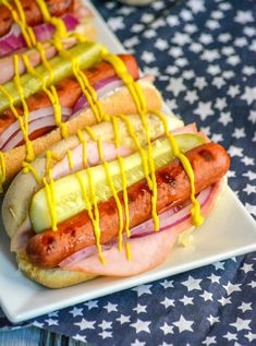 hot dogs with mustard and onions on a plate