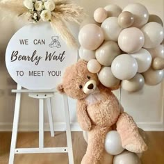 a brown teddy bear sitting on top of a white chair next to a bunch of balloons