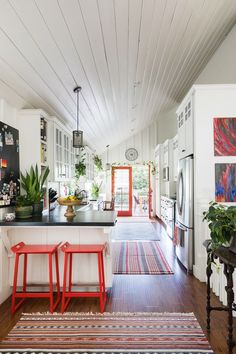 a kitchen with two stools and a rug on the floor