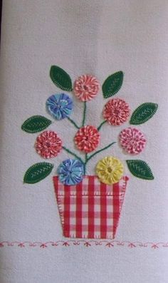 an embroidered dish towel with flowers in a basket