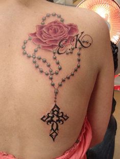 a woman with a rose and cross tattoo on her back