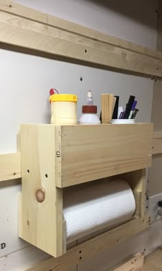 a wooden shelf with toilet paper and other items on it