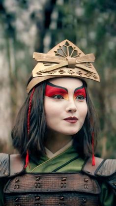 a woman dressed in costume with red and gold makeup