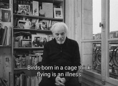 an old man sitting in front of a bookshelf with a quote about birds born in a cage think flying is an illusion