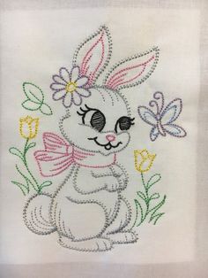 an embroidered bunny with flowers and butterflies on it