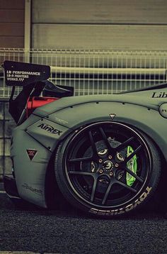 a grey sports car parked in front of a building