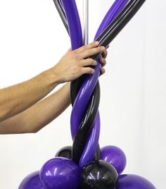 a man is holding onto some purple balloons