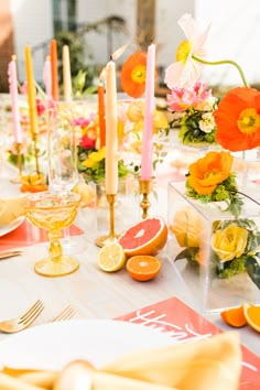 the table is set with oranges, watermelon and candles