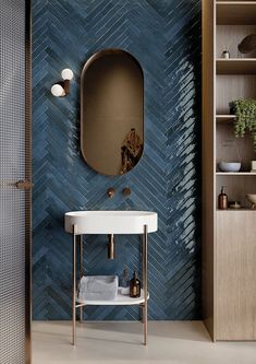 a bathroom with blue tiles and a mirror on the wall next to a white sink