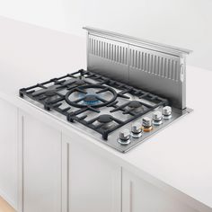 a gas stove top sitting on top of a white counter