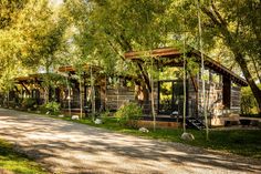 an old log cabin sits in the middle of a park with lots of trees and grass