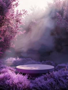 a round table surrounded by purple bushes and trees in the background with sunlight coming through the clouds