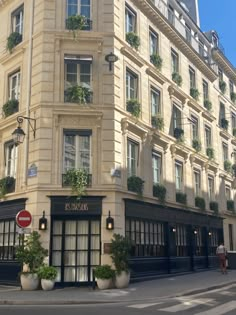 a large building with many windows and plants growing on the side of it's sides