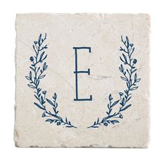 the letter e is made out of marble with blue leaves and branches on it's side