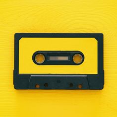 an old fashioned tape recorder on a yellow background