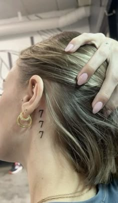 a woman with tattoos on her neck and behind her ear