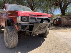 a red pick up truck parked in the dirt