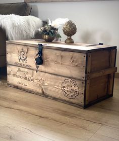 a wooden box sitting on top of a hard wood floor next to a brown couch