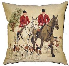 a pillow with two men on horses and dogs in front of them, both have their backs turned to the same direction