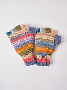 two multicolored knitted mittens sitting next to each other on a white surface