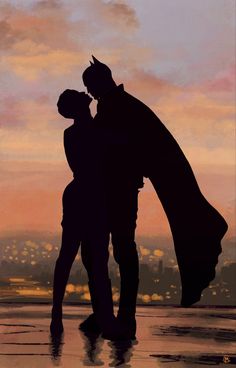 two people standing next to each other in front of a cityscape at sunset