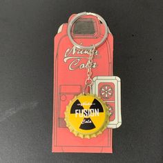 a bottle cap shaped keychain with a yellow and black logo