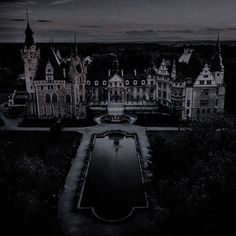 an aerial view of a castle with water in the foreground