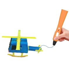 a person holding a pen and flying a toy helicopter