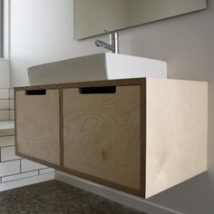 a kitchen sink and cabinets in a room with white tiles on the wall behind it