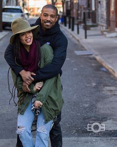 a man and woman are hugging on the street