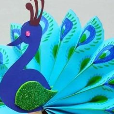 a close up of a paper peacock on a table