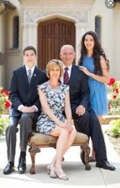 a family posing for a photo in front of a house