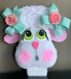 a close up of a stuffed animal with flowers on it's head and eyes