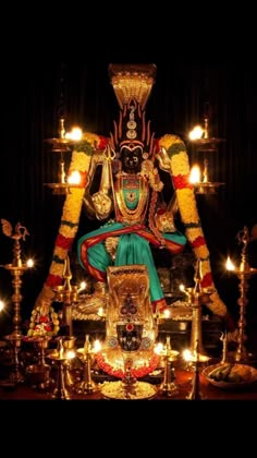 an idol sitting on top of a table surrounded by candles