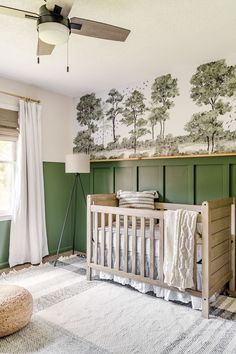 a baby's room with green walls and white curtains