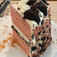 a piece of cake with oreo cookies and cream on it sitting on a plate