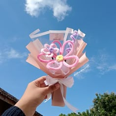 a person holding up a paper bouquet with flowers