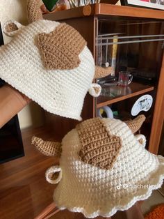 two crocheted stuffed animals sitting on top of a shelf