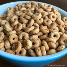 a blue bowl filled with cereal on top of a wooden table