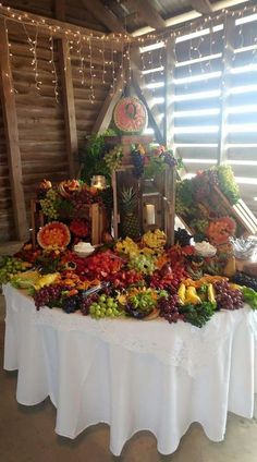 a table topped with lots of different types of fruits and vegetables next to a clock