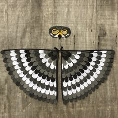 a black and white butterfly with gold accents on it's wings, sitting on a wooden surface